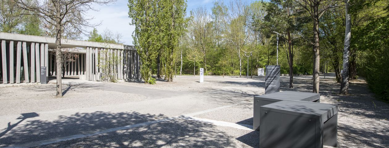 Gedenkstätte Dachau –  Platz vor dem Besucherzentrum mit Bäumen und Informationssäulen