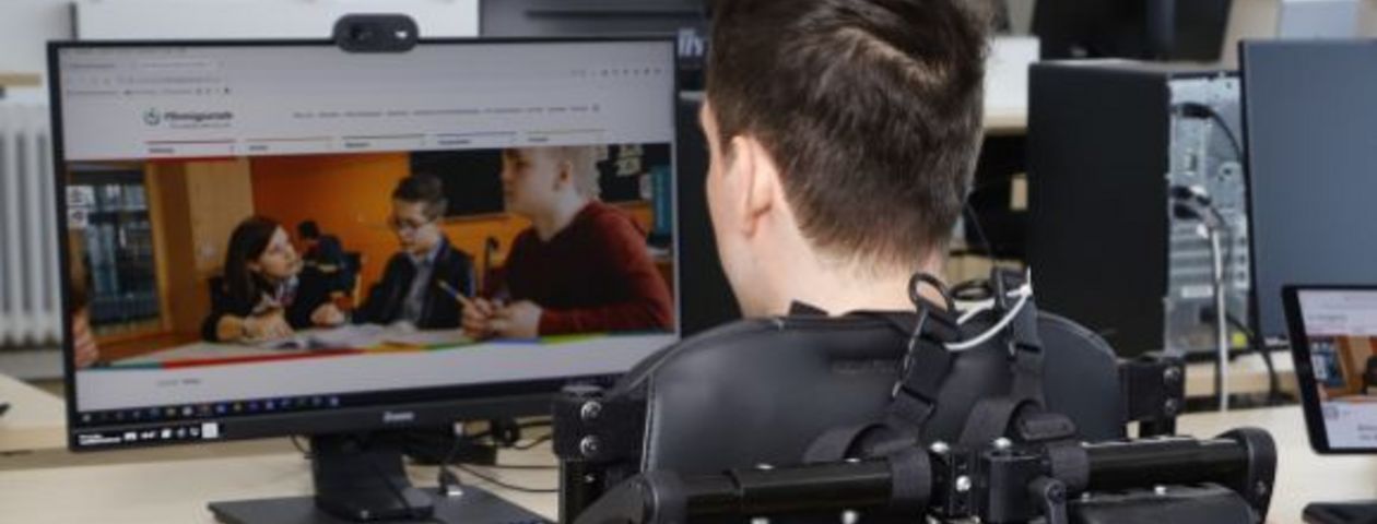 Mann im Rollstuhl vor Bildschirm