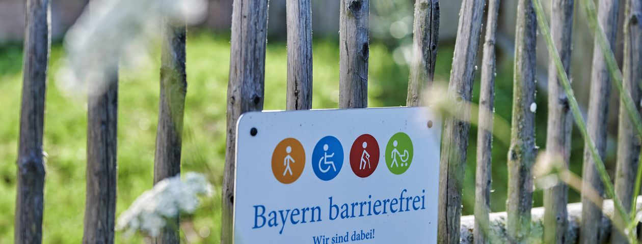 Das Signet mit den vier farbigen Symbolen, die für Menschen mit kognitiven Einschränkungen (orange), Personen im Rollstuhl (blau), ältere Menschen (rot) und Familien mit kleinen Kindern (grün) stehen.