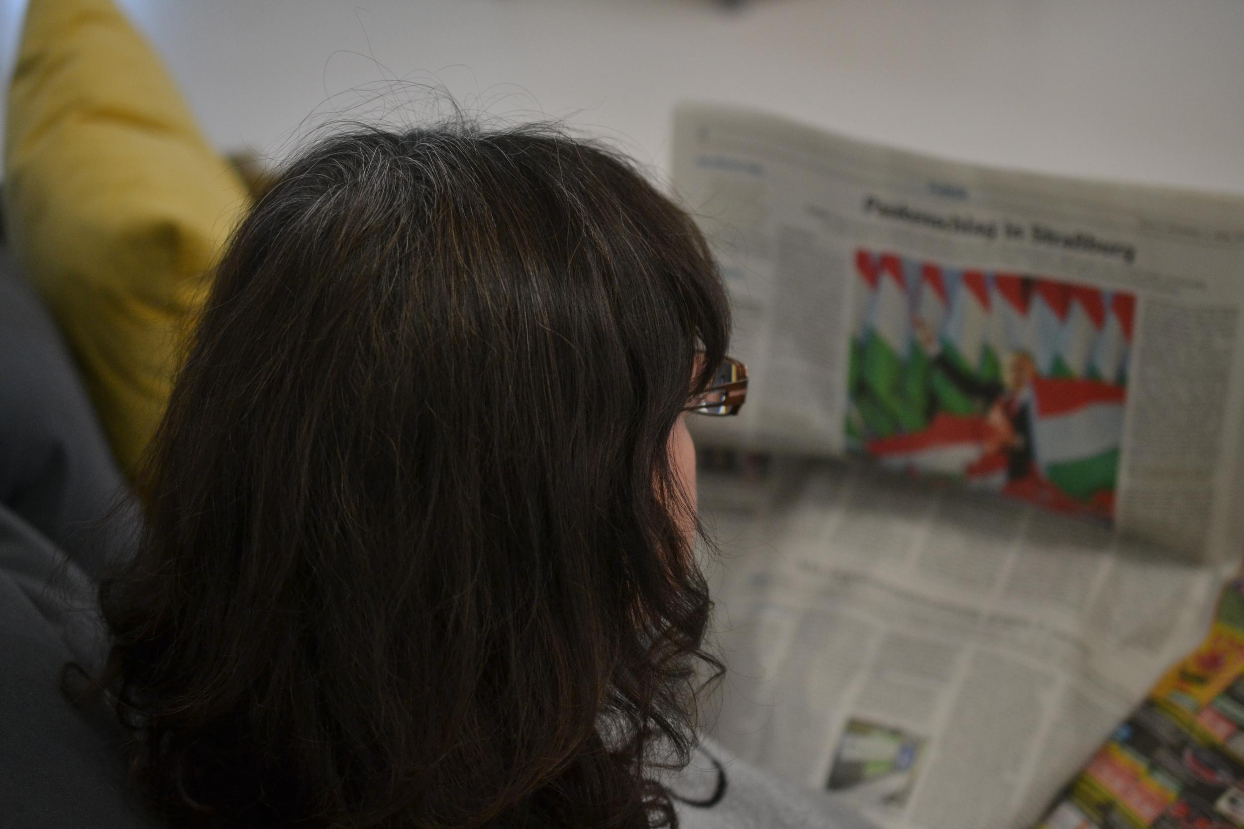 Frau liest Zeitung in Standard-Sprache.