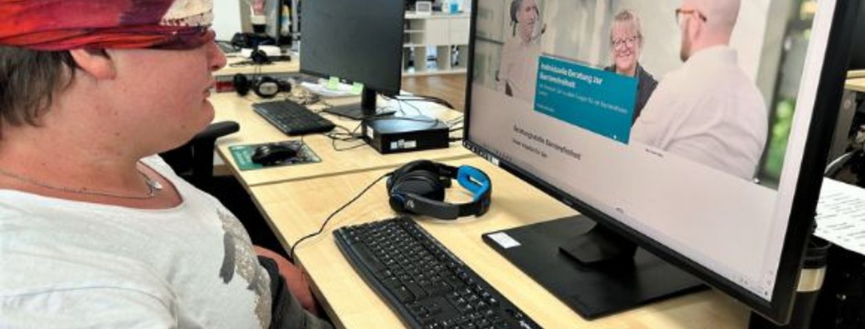 Frau mit Augenbinde vor dem Computer